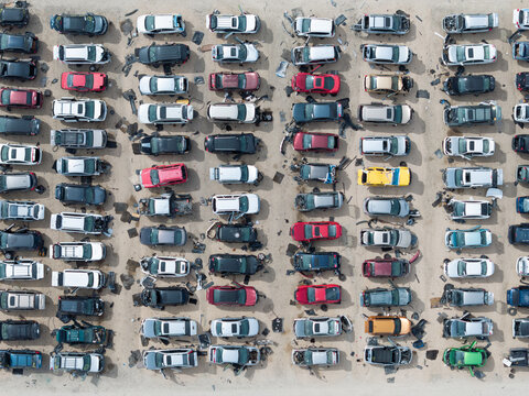 Top-down shot captures numerous scrapped cars in a scrap yard