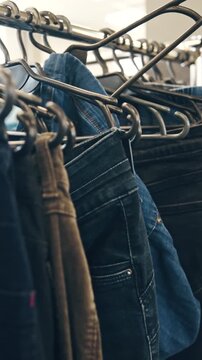Rows Of Used Denim Jeans Hanging In A Second-Hand Shop, Vertical Video