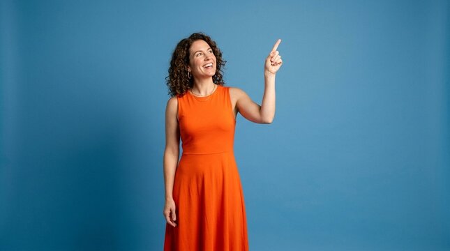 Woman in Orange Dress Pointing Finger Up Smiling &ndash; Product Advertisement Concept Blue