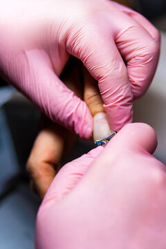Manicurist trimming customer nails at beauty salon, offering professional care