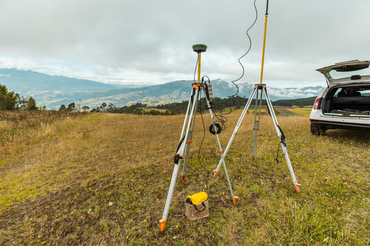 Land Surveyors Using GPS Equipment for Field Mapping in Rural Mountain Landscape