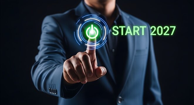 Person pressing glowing start button with year 2027 displayed on futuristic digital interface.