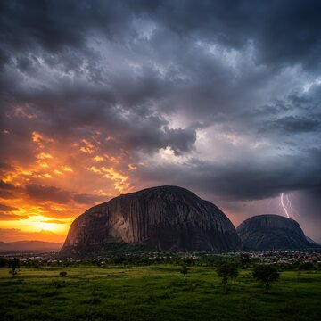 Dramatic Sunset and Lightning Storm over Zuma Rock in Nigeria Landscape with Majestic Monolith and Green Plains
