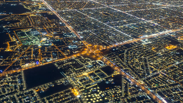 RIYADH, SAUDI ARABIA - JUNE 1, 2026: High altitude aerial view of Riyadh city at night showing illuminated street grids and highway interchanges from an airplane window