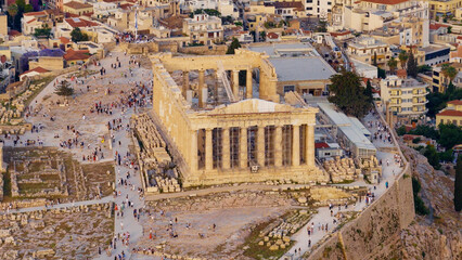 Obraz premium Acropolis parthenon stands on the iconic athenian hilltop, attracting numerous tourists exploring this significant ancient greek historical site and its surrounding city landscape