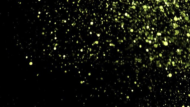 Gold dust particles fly in slow motion in the air lingering slowly. Dust Particles Background Bokeh Lights Background on Black Background 4k Footage Particles Background.