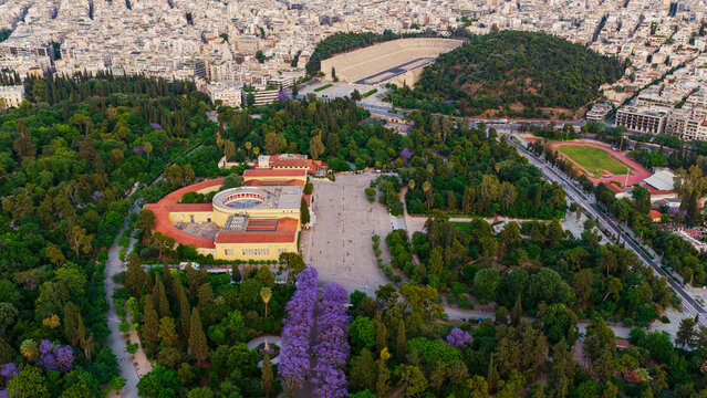 Aerial view of athens featuring the zappeion hall and the panathenaic stadium surrounded by the lush national garden, highlighting the historic architecture and urban landscape of the greek capital