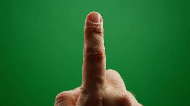 Male hand showing middle finger gesture on green screen background.