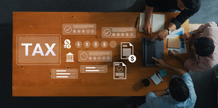 A top-down view of professionals collaborating on tax preparation in an office setting, surrounded by financial documents, digital icons, and tools for analysis. Gantry