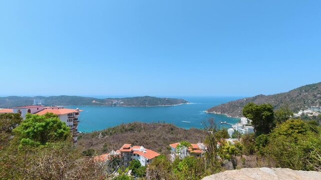 Scenic view of Puerto Marques Bay, mountains, and buildings from a highway viewpoint in Acapulco