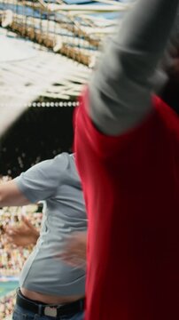 Vertical Video Excited diverse supporters jumping after winning live bet result, stadium crowd with adrenaline enjoying team victory, happy fans celebrate successful sports betting with raised fists