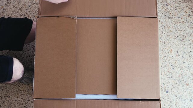 Businessman, man opening big box or cutting with package in warehouse for logistics, return order. Male person, distributor or supplier opening cargo or parcel, courier security distribution