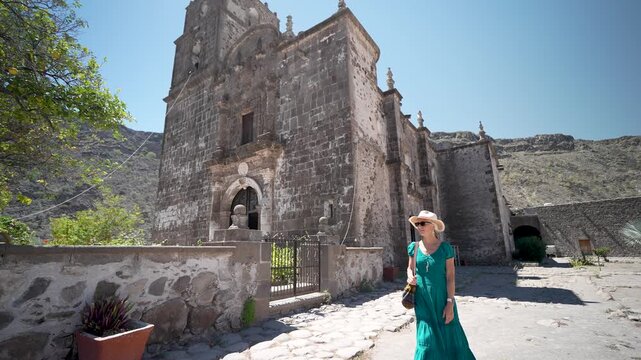 Mature woman enjoys exploring San Javier Mission at sunrise in Loreto, Baja California Sur, Mexico, discovering the desert oasis
