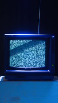 Retro TV, vintage television In a nostalgic setup, a retro TV displays grain on screen, scary halloween night device good for chroma key and green screen