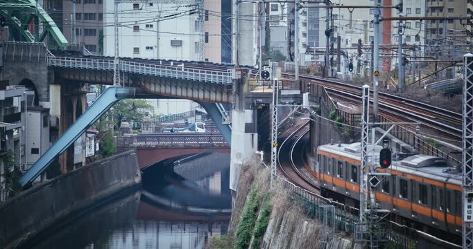 Canal and Rail Viaducts Foreground, Orange and Yellow Trains Converging Tokyo