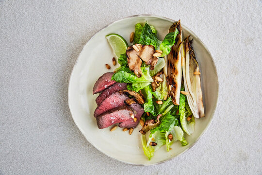 Grilled Steak Salad with Charred Endive, Mushrooms and Pine Nuts