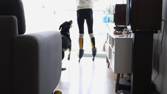Teenager Girl Roller Skating Down Apartment Hallway With Dog