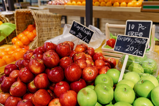 Fresh apples are displayed inside the fruit section at a supermarket
