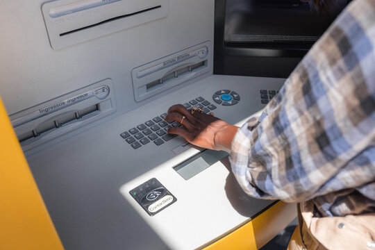 Woman entering password at ATM