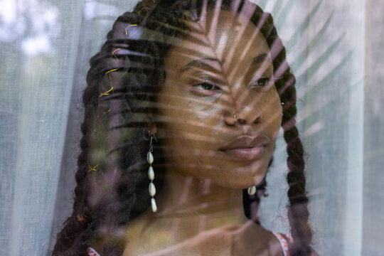 african woman portrait closeup, female face with palm leaf shadow