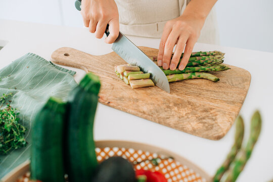 Close up of female hands cutting asparagus