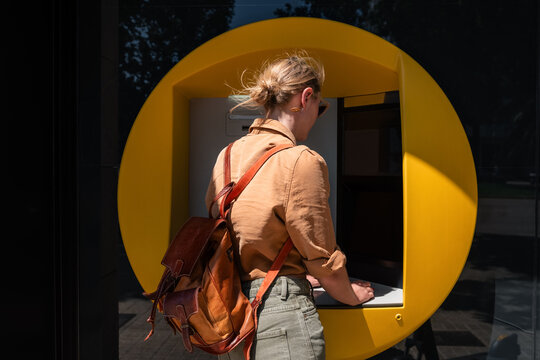 Woman Using an ATM at a Bank During the Day