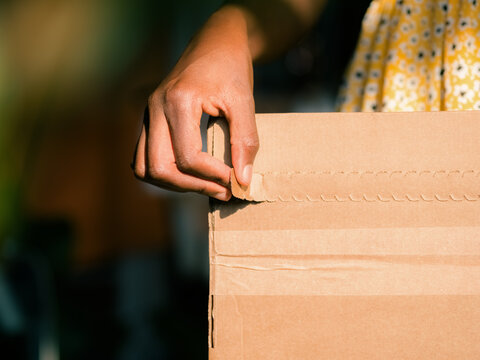 Person Opens a Cardboard Box at home