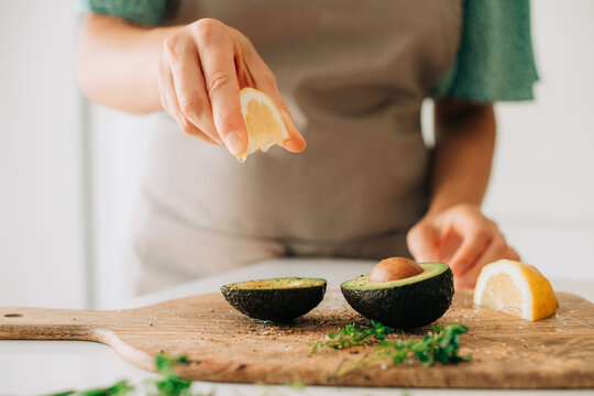 Close-up of lemon juice dripping onto avocado halves