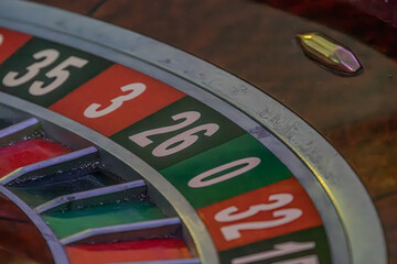 Obraz premium Close-up view of a lit roulette wheel with alternating red and black numbered slots Perspective from above, no additional context or embellishment