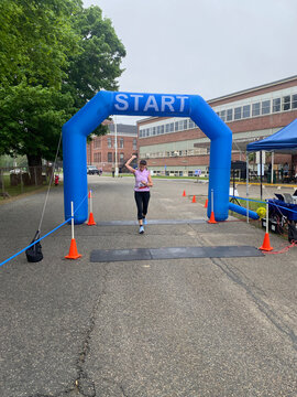 middle aged runner running into finish line 