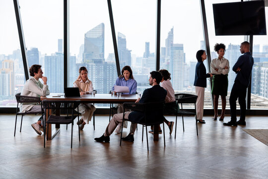 Diverse professionals working in high-rise office with city view