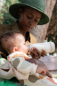 Mother feeding baby with formula from bottle 