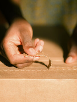 Opening a Cardboard Box With Hands in Sunshine