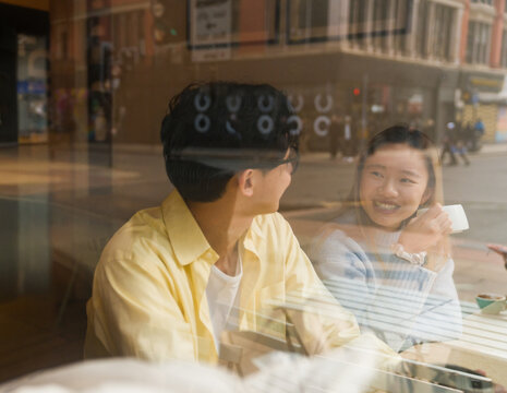 Asian Couple Enjoying a Conversation at a Cafe