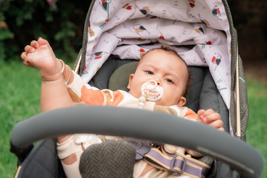 Baby with pacifier in stroller 