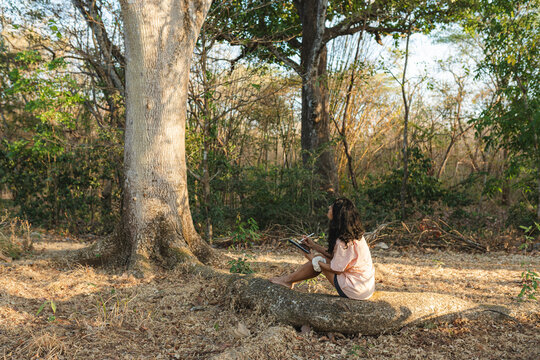Woman creating digital art on digital tablet in forest