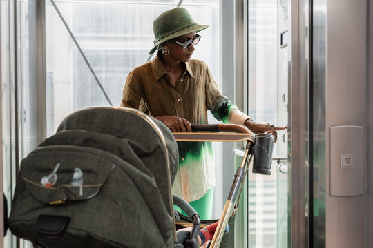 Woman With Stroller Enters Elevator in Urban Setting
