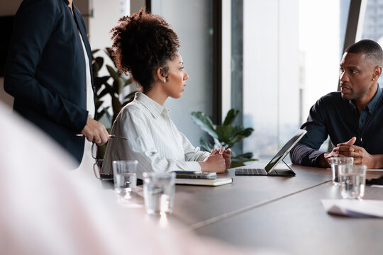 Business professionals having serious discussion in a modern boardroom