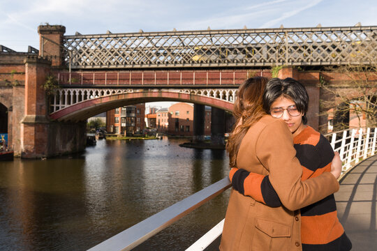 Couple Hugging on a Bridge by the Water in Manchester