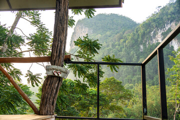 Fototapeta premium Relaxing retreat in nature with wooden railing and lush greenery at sunset