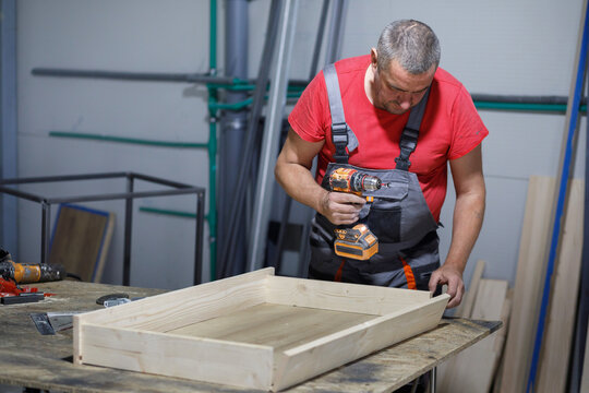 Man works with electric screwdriver