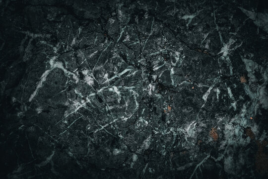 Dark and moody high-key macro close-up of abstract black marble texture with subtle white veins in stone