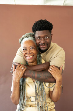Family Members Share a Hug on a Brown Backdrop in a Studio Setting