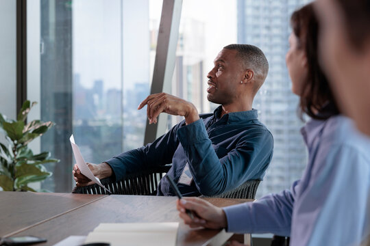 Professional leading discussion with document in team meeting