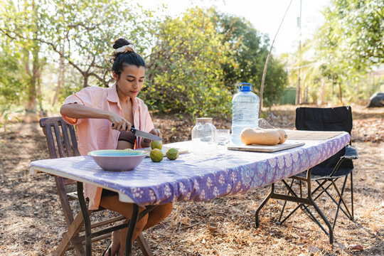 Adult slicing fresh fruit outdoors enjoying healthy lifestyle