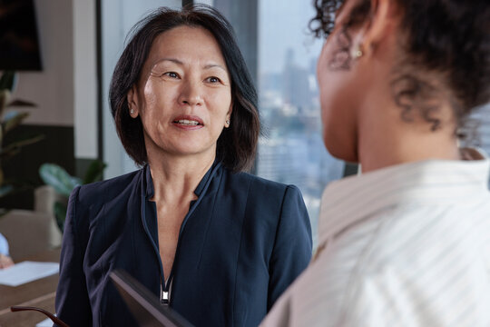 Two businesswomen in a modern office having a discussion.