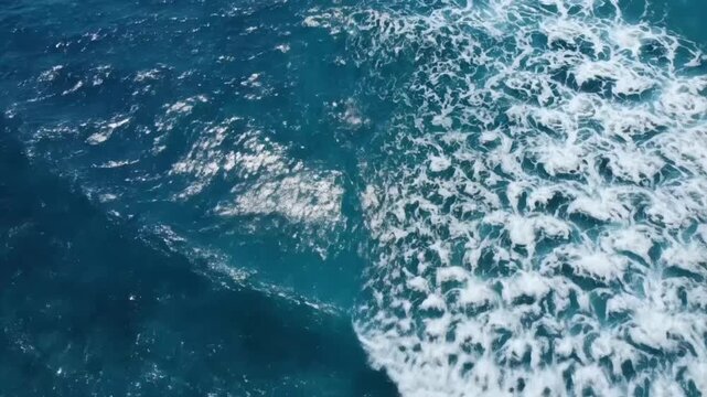 View of blue ocean waves from above, movement of water and sunlight on surface, VSRExport