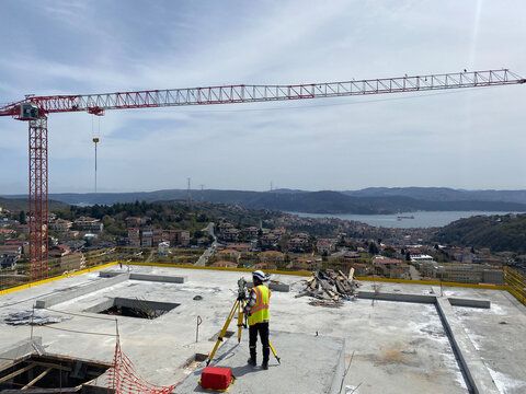 Land Surveyor Measuring at Construction Site with Total Station