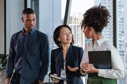Diverse business team in discussion with city view backdrop.