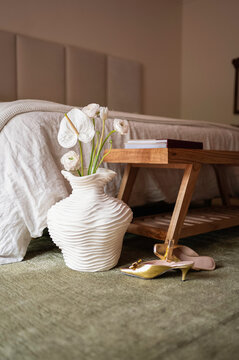 Decorative Vase With Flowers Near a Bed and a Shoe in a Room
